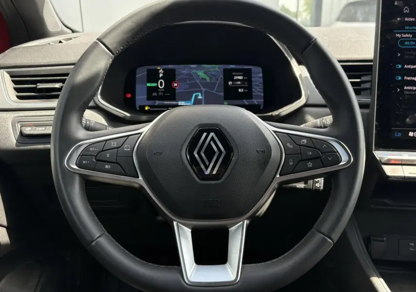 Vue centrée sur le volant cuir multifonctions Renault Captur E-Tech 2025 avec tableau de bord numérique et écran tactile.