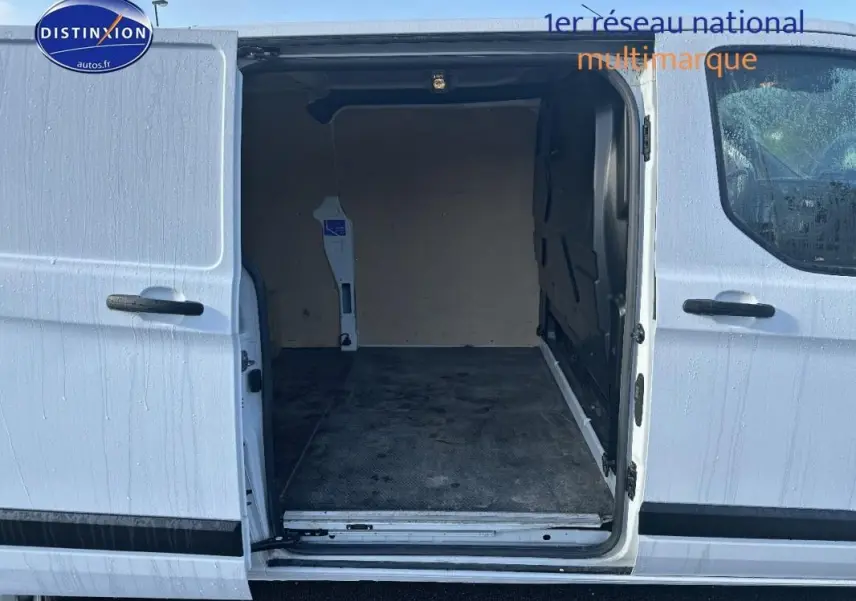 Vue latérale du fourgon blanc Ford Transit Custom avec porte latérale coulissante ouverte montrant l'espace de chargement vide.