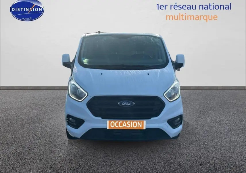 Vue avant d’un Ford Transit Custom fourgon blanc 2021 avec calandre noire et plaque « OCCASION » visible.