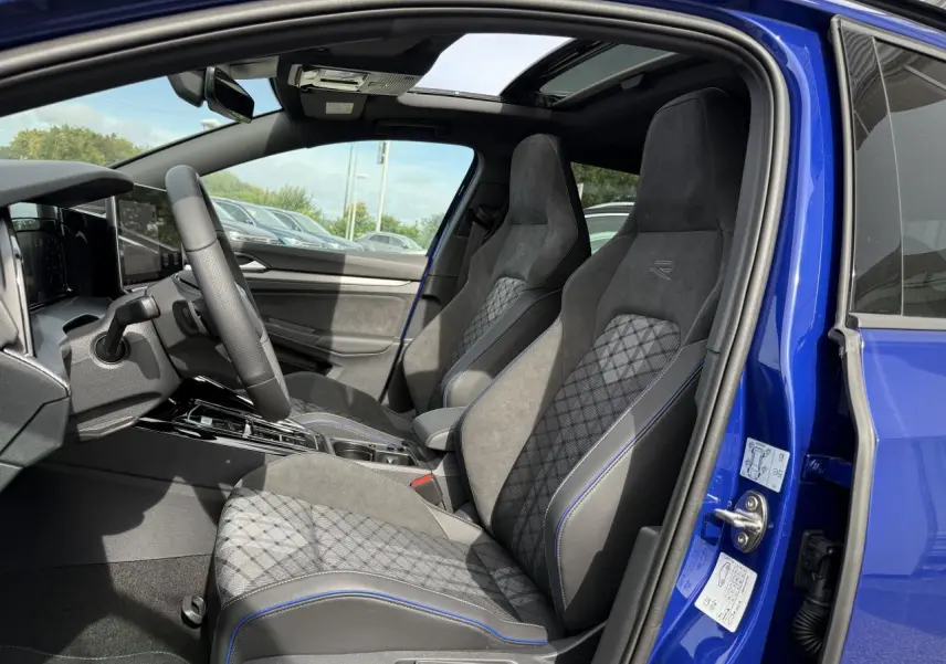 Vue intérieure côté gauche de la Volkswagen Golf 1.5 eTSI 2025 Bleu Lapiz, sièges sport R-Line en tissu et ArtVelours.