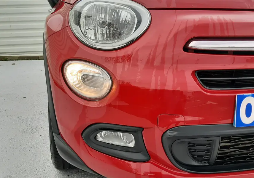 Gros plan sur la jante argentée avec logo FIAT 500 d'un FIAT 500X rouge, mettant en valeur le pneu ContiEcoContact.