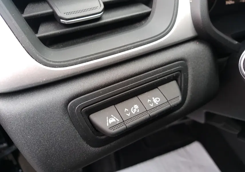 Gros plan sur les boutons de réglage d'assistance et éclairage côté gauche du tableau de bord du Renault Captur noir 2021.