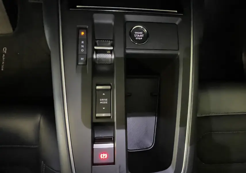 Vue plongeante sur la console centrale noire du Citroën C5 Aircross 2024 avec bouton start/stop et commandes de boîte auto.