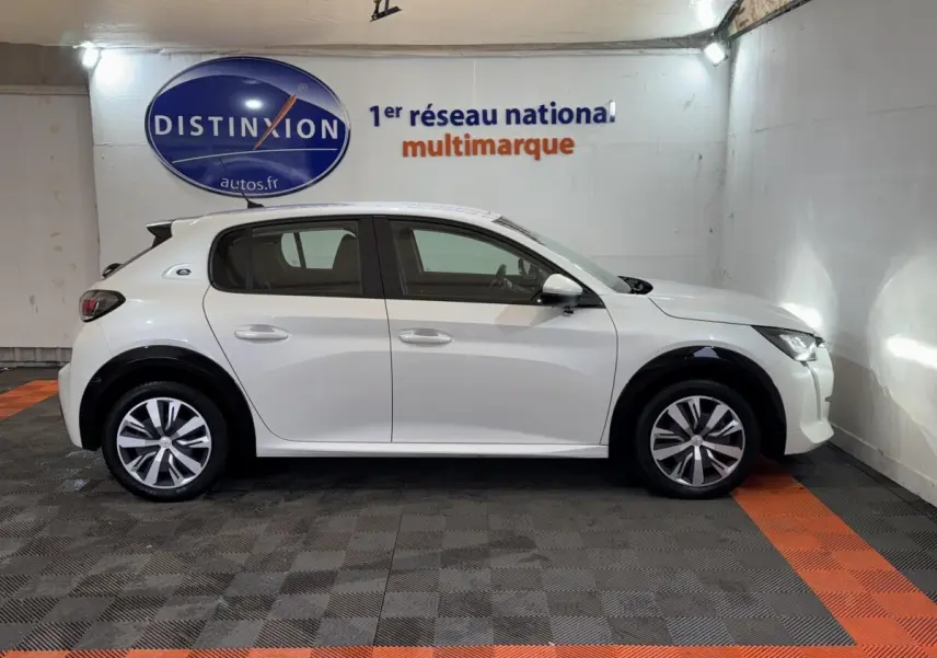 Peugeot 208 électrique blanche vue de profil côté gauche, avec jantes alliage et toit noir contrasté.