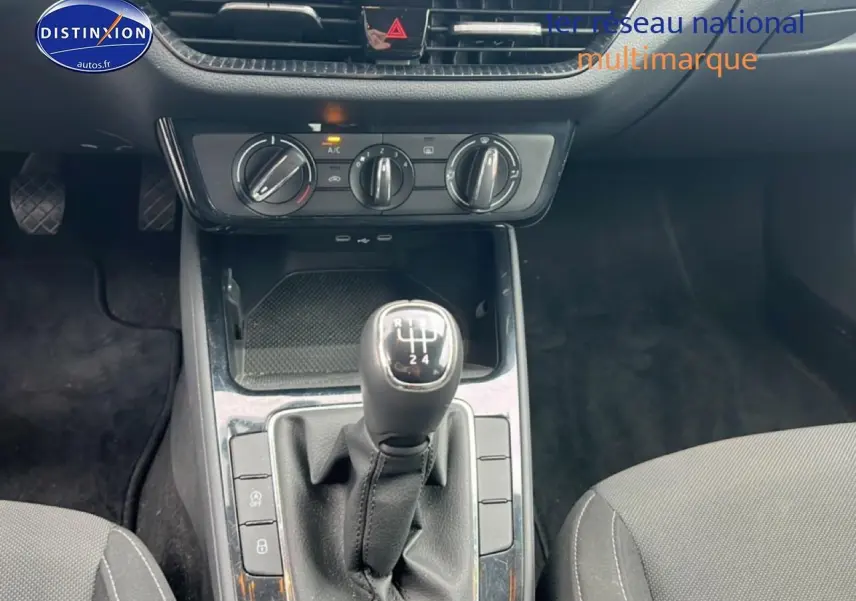 Vue rapprochée de la console centrale intérieure de la Skoda Fabia blanche 2025 avec levier de vitesse manuel et commandes de climatisation.