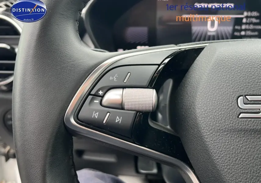 Gros plan sur les commandes gauche du volant cuir multifonction de la Skoda Fabia blanche 2025.