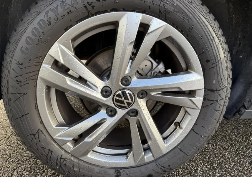 Gros plan sur la jante alliage gris galvanisé Valencia 17 pouces avec logo Volkswagen au centre, pneu Goodyear humide.