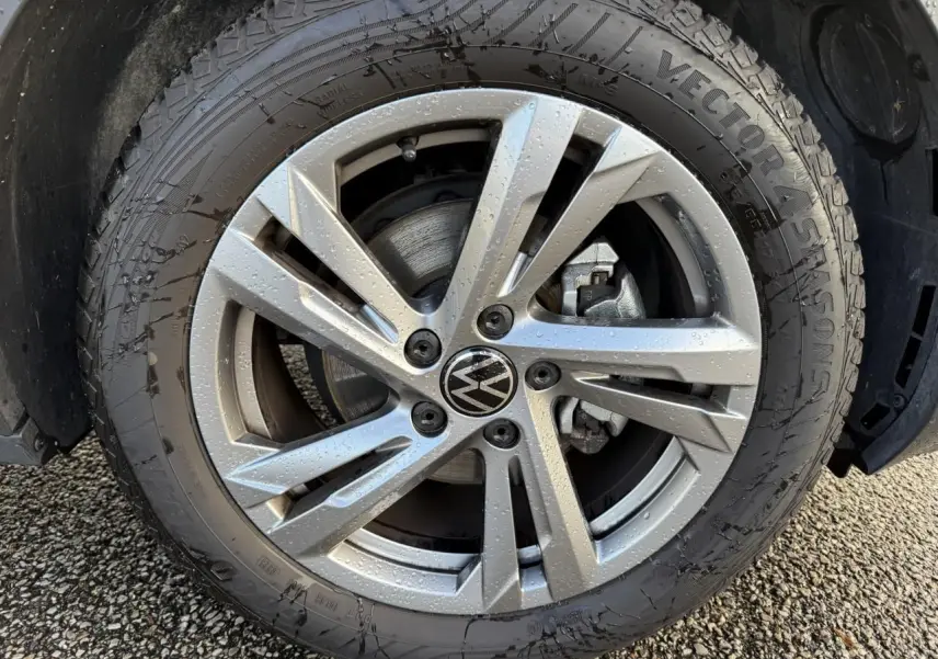 Gros plan sur la jante en alliage léger gris galvanisé 17 pouces avec logo Volkswagen au centre, roue mouillée.