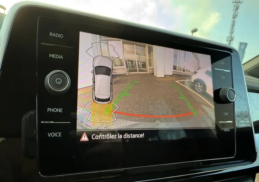 Écran tactile du système de navigation Discover Media montrant la caméra de recul du Volkswagen T-Roc bleu.