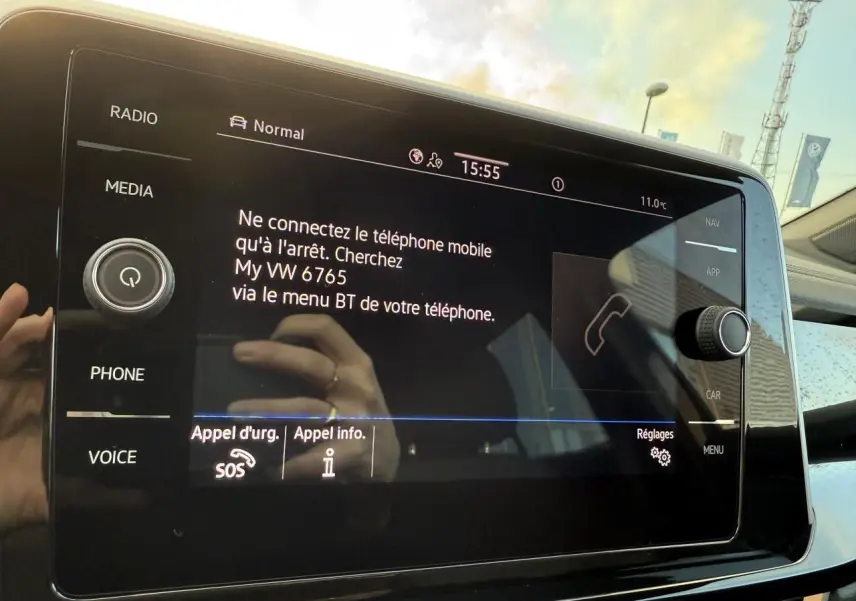 Écran tactile central du Volkswagen T-Roc bleu 2025 affichant les instructions de connexion Bluetooth.