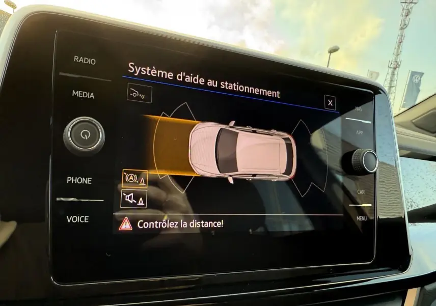 Écran tactile du système d'aide au stationnement de la Volkswagen T-Roc 2025, vue intérieure du tableau de bord.