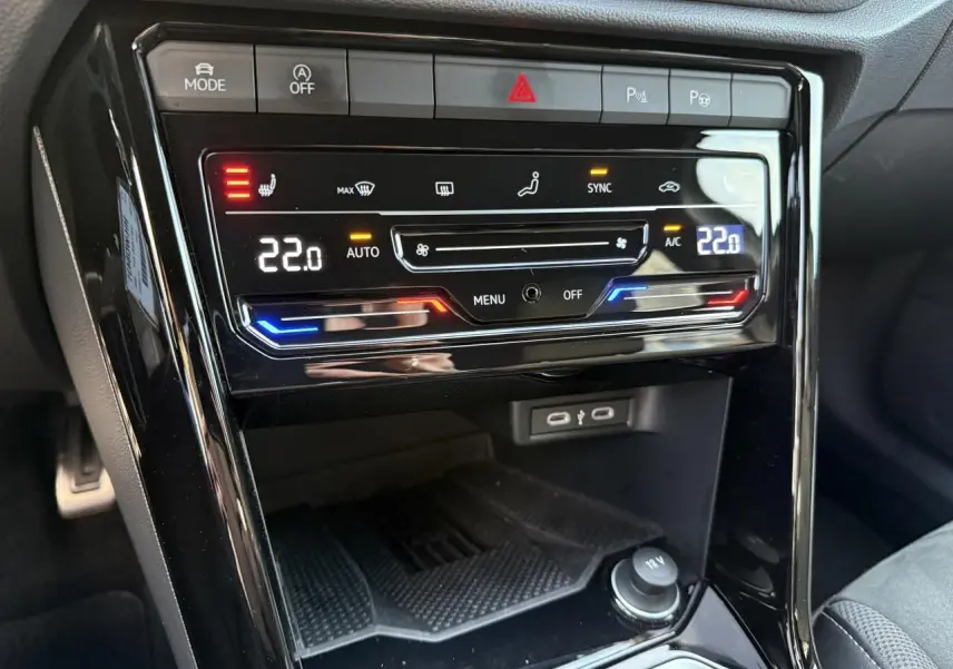 Détail de la console centrale noire du Volkswagen T-Roc 2025 montrant la climatisation automatique tactile et les ports USB.