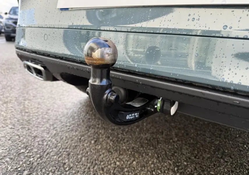Gros plan sur l'attelage amovible noir sous le pare-chocs arrière bleu du Volkswagen T-Roc 2025.