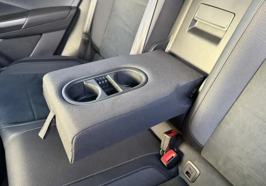 Accoudoir central arrière déployé avec porte-gobelets dans l’habitacle noir du Volkswagen T-Roc 2025.