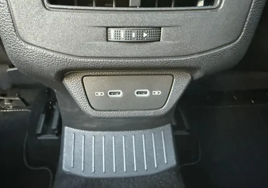 Gros plan sur la console arrière noire du Volkswagen T-Roc 2025 avec deux ports USB-C visibles.
