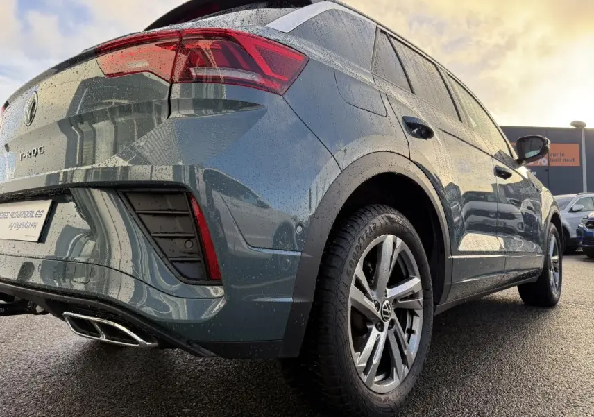 Vue 3/4 arrière droite du Volkswagen T-Roc bleu 2025 avec jantes alliage et feux arrière LED distinctifs.