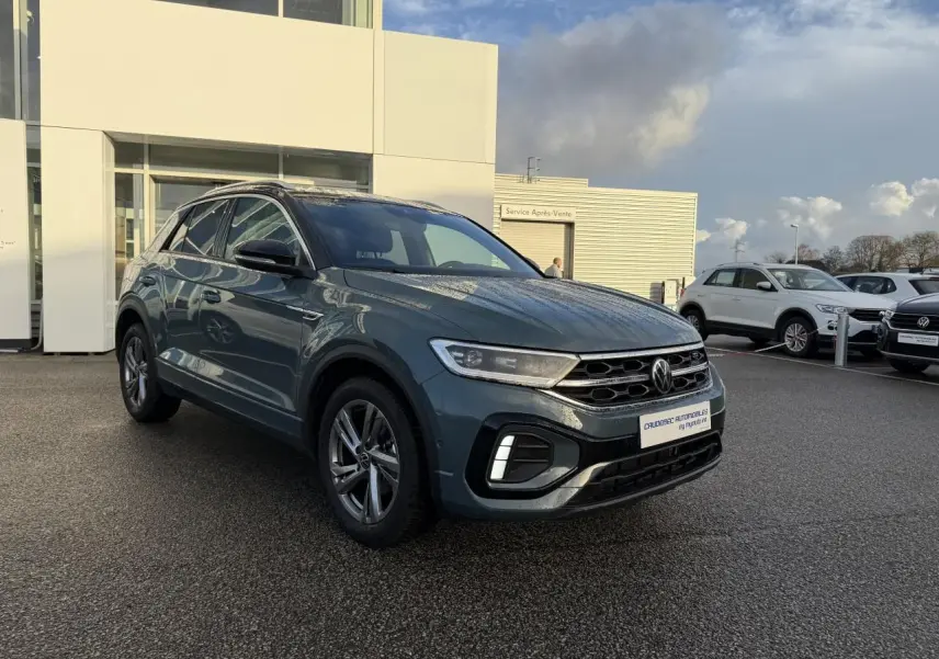 Volkswagen T-Roc bleu en vue 3/4 avant droit, avec jantes alliage et calandre noire brillante.