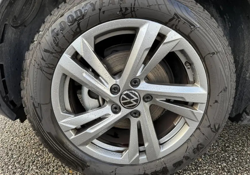 Gros plan sur une jante en alliage léger gris galvanisé de 17 pouces avec logo Volkswagen au centre, pneu Goodyear humide.