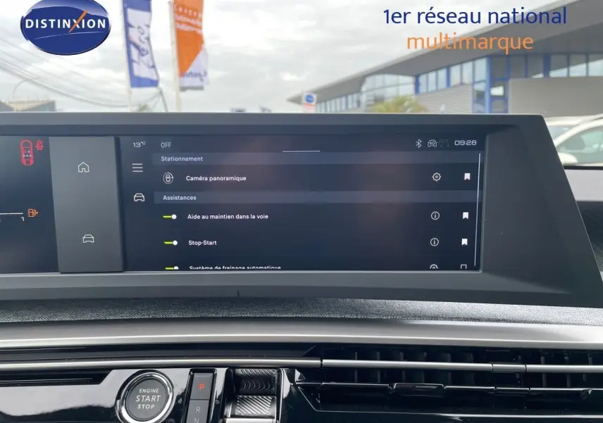 Intérieur du Peugeot 3008 Hybrid 2025 montrant l'écran tactile central et le bouton start/stop sur tableau de bord noir.