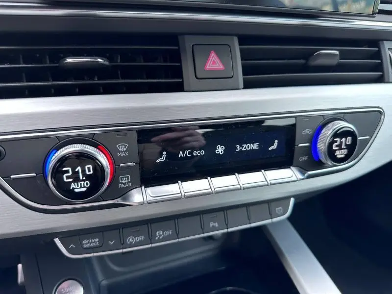 Détail du tableau de bord de l'Audi A5 Cabriolet 2023 montrant la climatisation automatique tri-zone à 21°C.