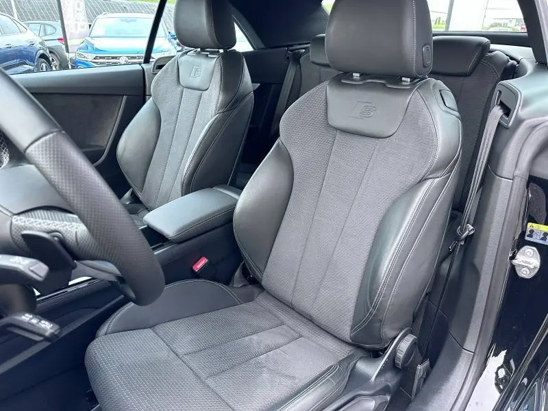 Intérieur noir de l'Audi A5 Cabriolet 2023, vue rapprochée des sièges avant sport avec logo S embossé.