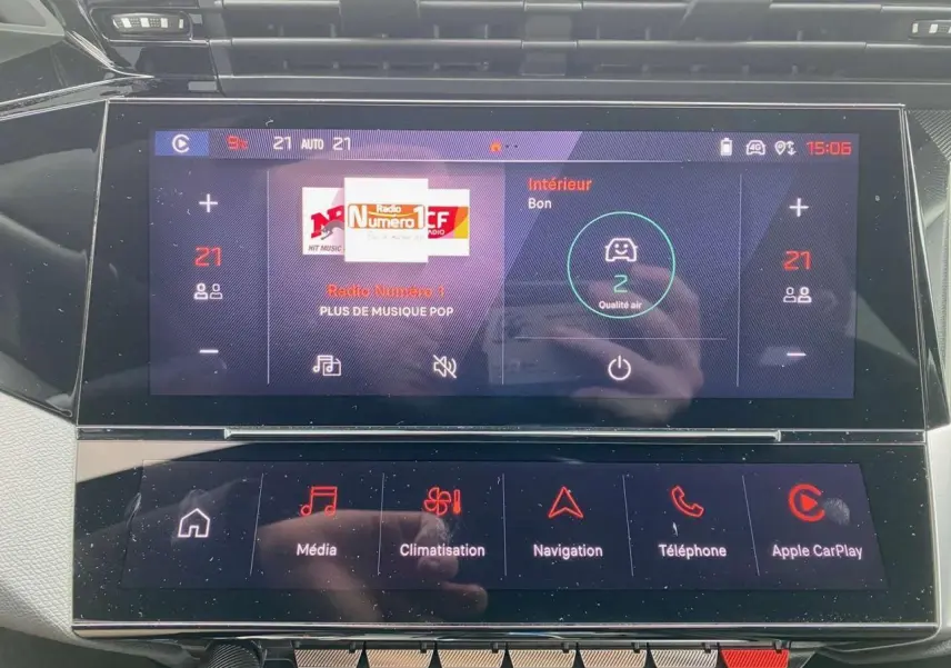Écran tactile central de la Peugeot 308 GT 2022 affichant la climatisation et la radio, intérieur moderne et épuré.