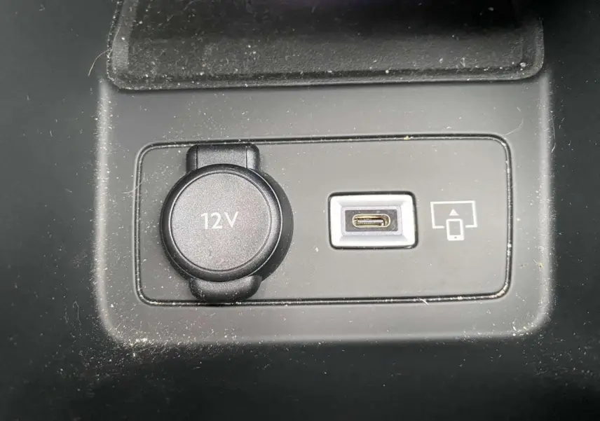 Prise 12V et port USB-C pour smartphone dans l'habitacle de la Peugeot 308 GT rouge Elixir, vue rapprochée du tableau central.