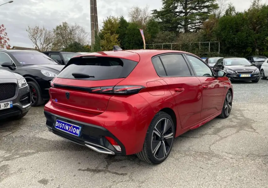 Peugeot 308 GT rouge Elixir vue 3/4 arrière droit, avec feux arrière LED et jantes alliage distinctives.