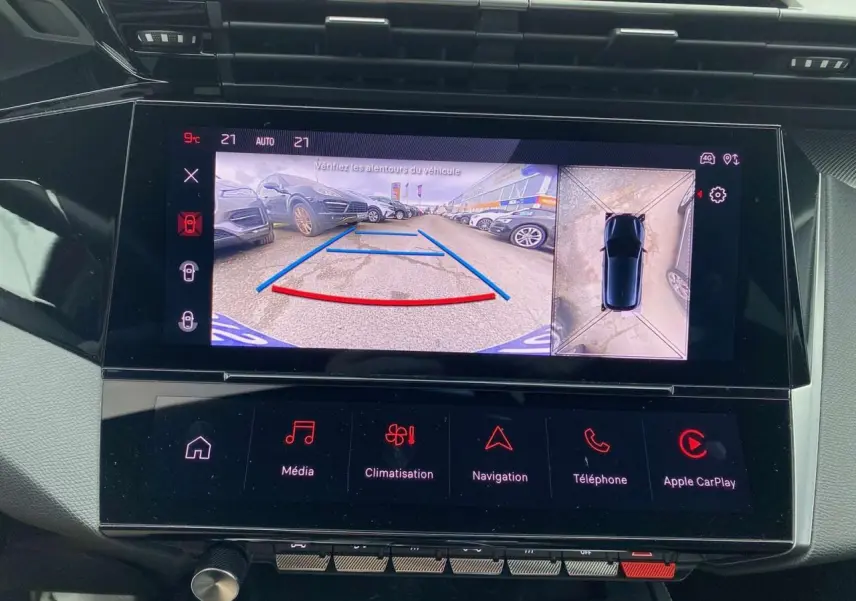Écran central tactile montrant la caméra 360° avec vue arrière et dessus d'une Peugeot 308 rouge Elixir.