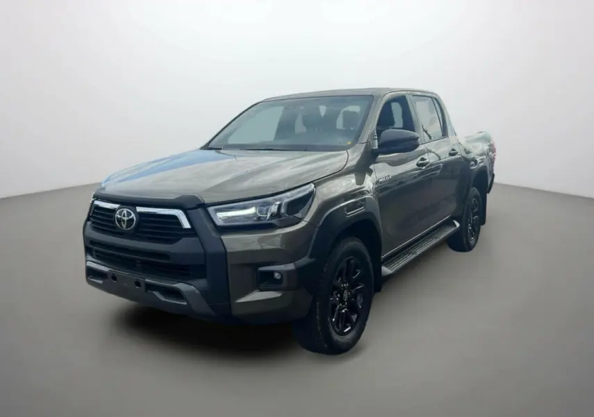 Toyota Hilux 2025 bronze impérial en 3/4 avant droit, avec calandre noire et jantes alliage noires distinctives.