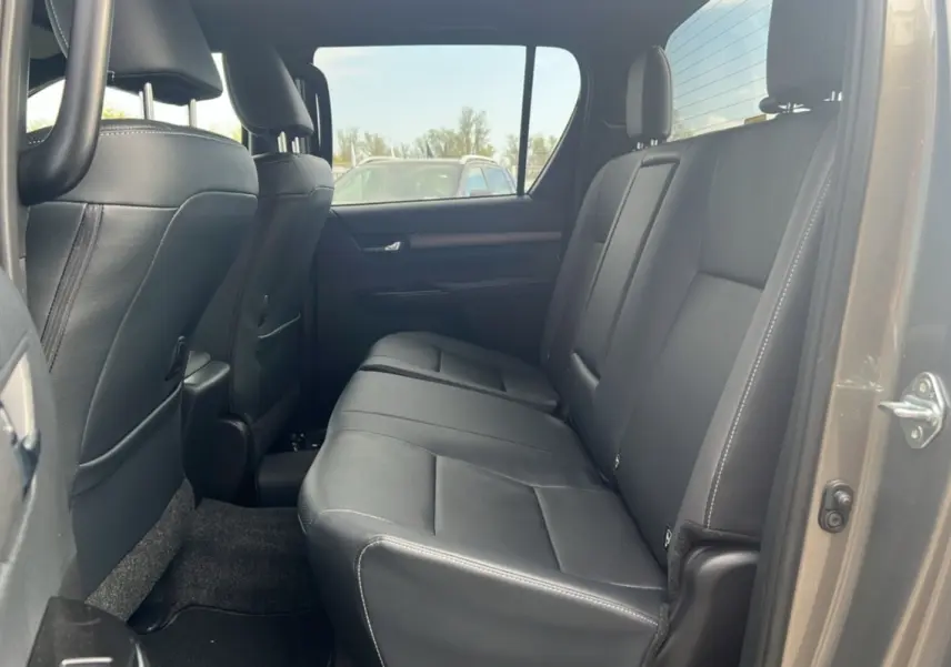Vue intérieure côté droit sur la banquette arrière en cuir noir du Toyota Hilux 2025 bronze impérial Invincible 4x4