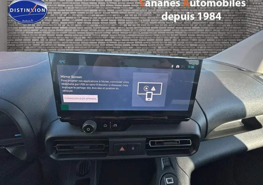 Vue intérieure du tableau de bord du Citroën Berlingo blanc 2025 avec écran tactile central et commandes de climatisation.