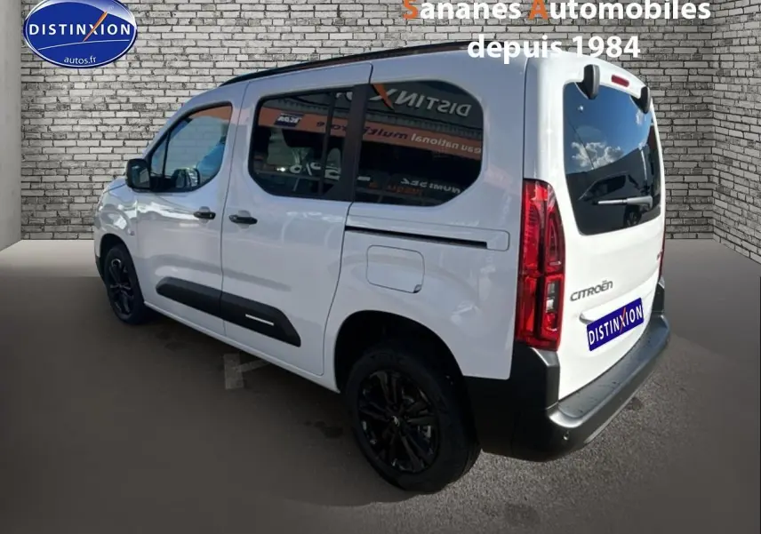 Vue 3/4 arrière droite d'un Citroën Berlingo blanc avec vitres arrière surteintées et jantes alliage noires.