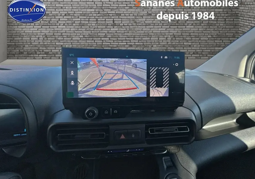 Vue rapprochée de l’écran central du tableau de bord du Citroën Berlingo blanc, affichant la caméra de recul.