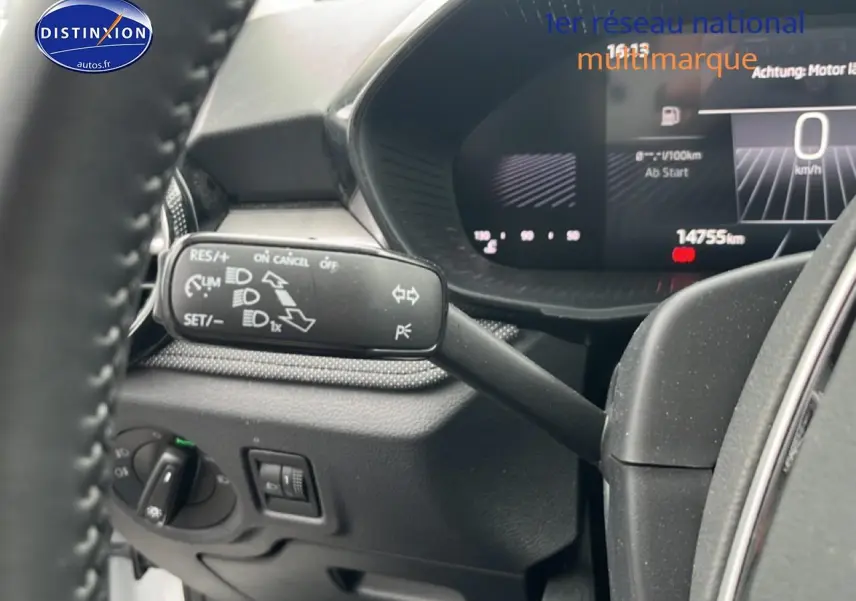 Vue intérieure centrée sur le combiné d'instruments et la commande de clignotants d'une Skoda Fabia blanche 2025.