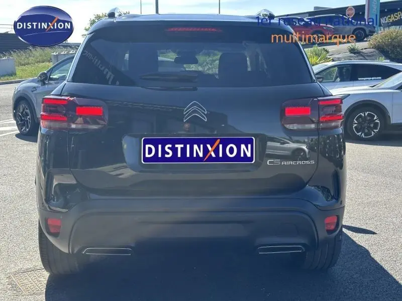 Vue arrière d'un Citroën C5 Aircross noir Perla Nera 2025 avec feux LED et logo distinctif sur parking.