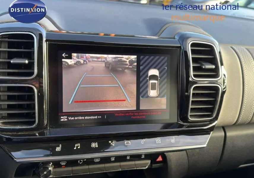 Vue rapprochée de l’écran central du tableau de bord du Citroën C5 Aircross gris, affichant la caméra de recul et l’aide au stationnement.