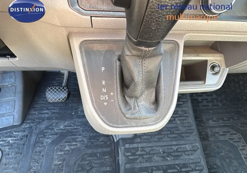 Le levier de vitesse automatique noir du Volkswagen Crafter 35 L3H3 2.0 TDI, vu de dessus avec pédales et prise 12V.