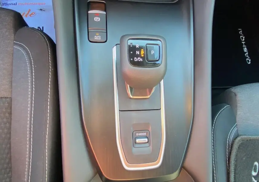 Vue rapprochée de la console centrale noire du Nissan Qashqai 2023 avec levier de vitesses automatique et bouton D-Mode.