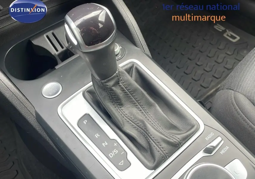Le levier de vitesses automatique noir en cuir de l'Audi Q2 35 TFSI S-Line, vue rapprochée de la console centrale.