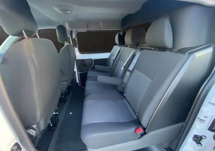 Vue intérieure côté droit du Peugeot Expert Cabine Approfondie 2025, sièges tissu bi-ton gris et noir sur 3 places arrière.