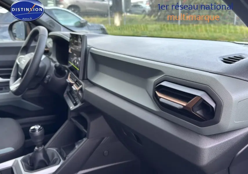 Intérieur du Dacia Bigster 2025 vue côté passager, tableau de bord gris avec aérateurs hexagonaux cuivrés.