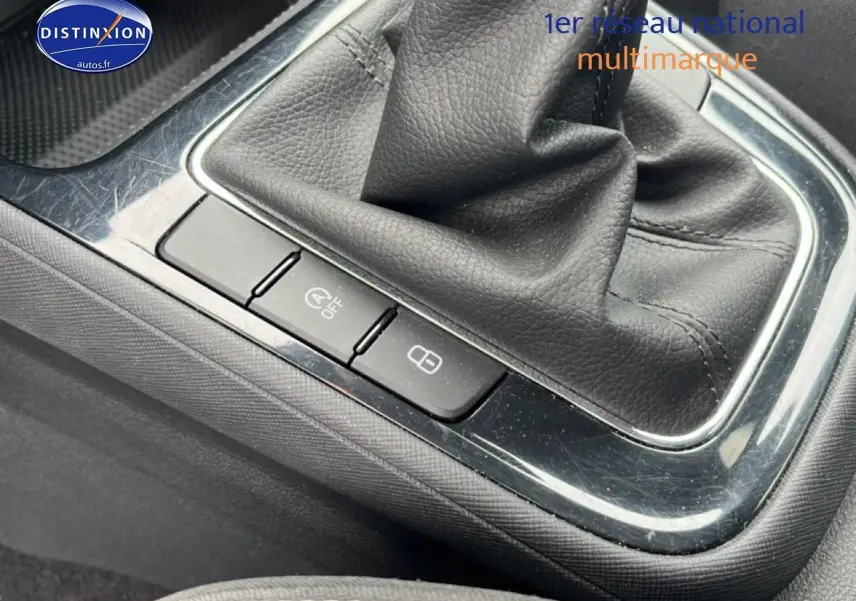Gros plan sur la console centrale noire avec levier de vitesse cuir et boutons de verrouillage et arrêt auto start d'une Skoda Fabia bleue 2025.