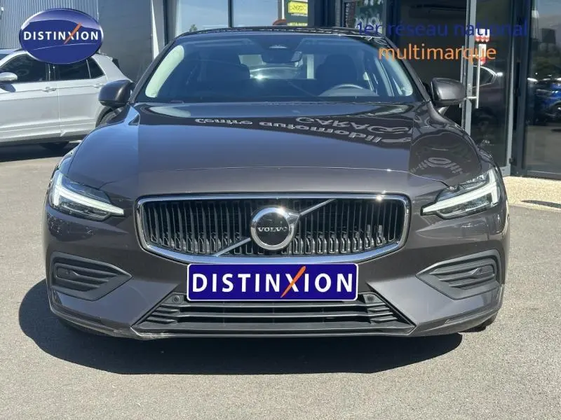 Vue avant d'une Volvo S60 B4 gris Platinium métallisé avec calandre noire et phares LED distinctifs.