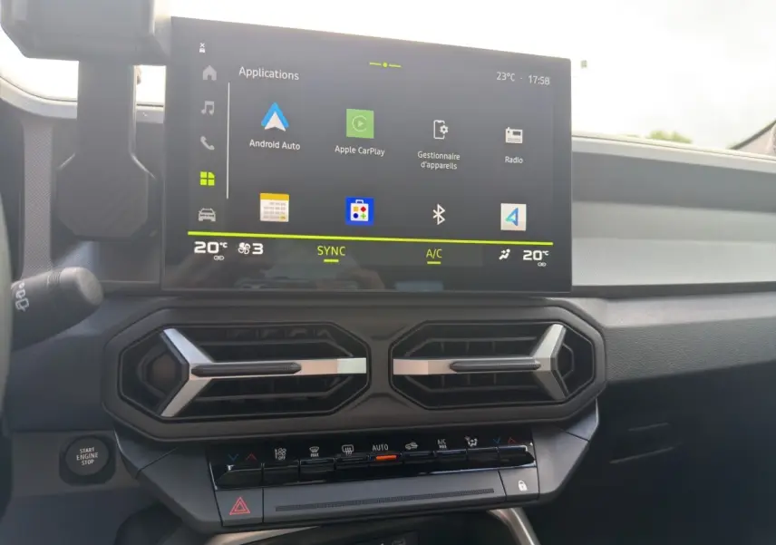 Vue rapprochée du tableau de bord du Dacia Bigster Journey hybride 2025, écran tactile multifonctions et commandes climatisation visibles.