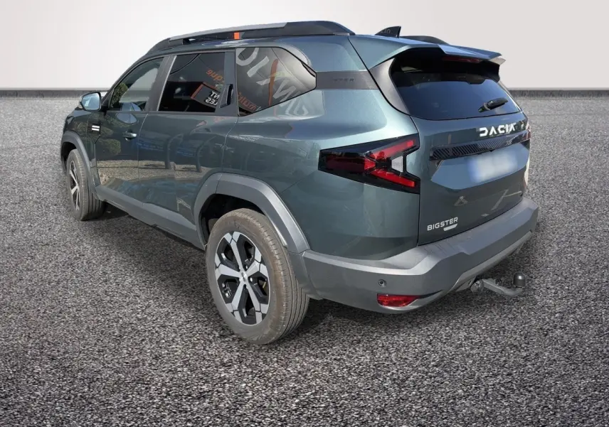 Vue 3/4 arrière droite d'un Dacia Bigster vert avec attelage et feux arrière LED distinctifs.