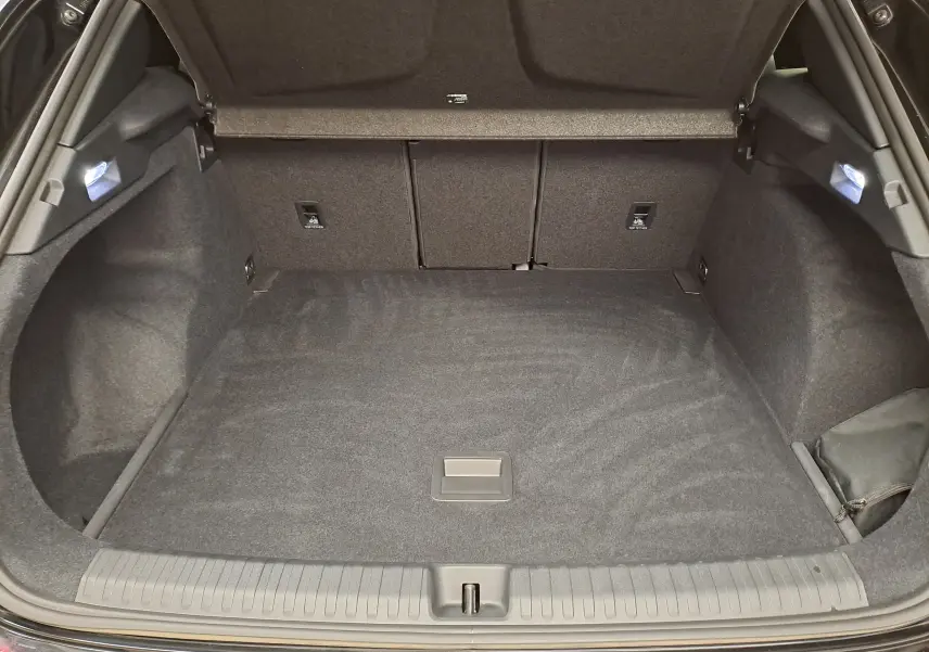 Coffre ouvert vu de l'arrière d'une CUPRA TERRAMAR Noir Minuit, espace de chargement propre et éclairé.