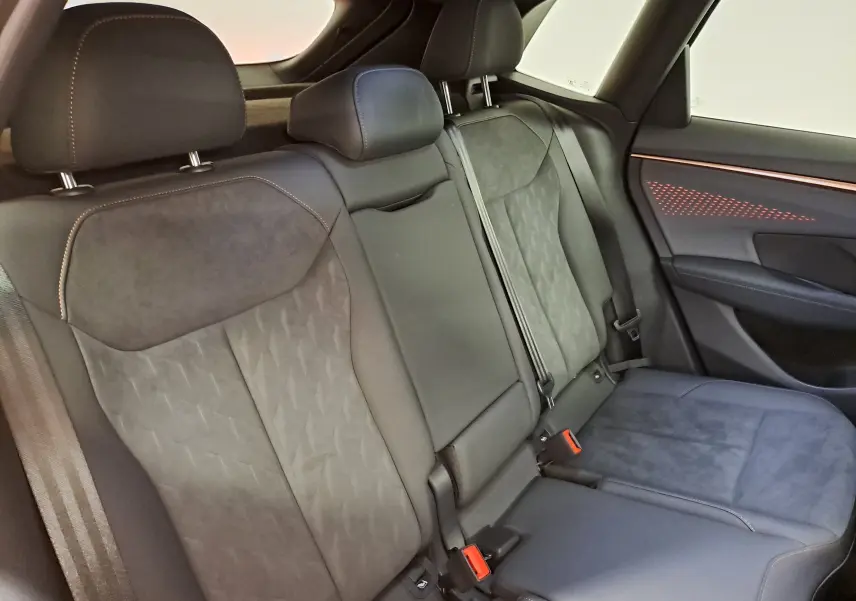 Vue intérieure du siège arrière droit de la CUPRA TERRAMAR 2025, sellerie noire avec surpiqûres contrastantes et éclairage d'ambiance rouge.