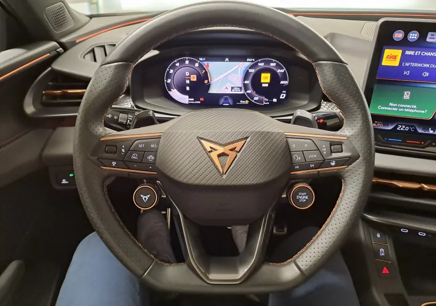Vue intérieure centrée sur le volant perforé avec logo CUPRA et tableau de bord numérique du Terramar 2025.