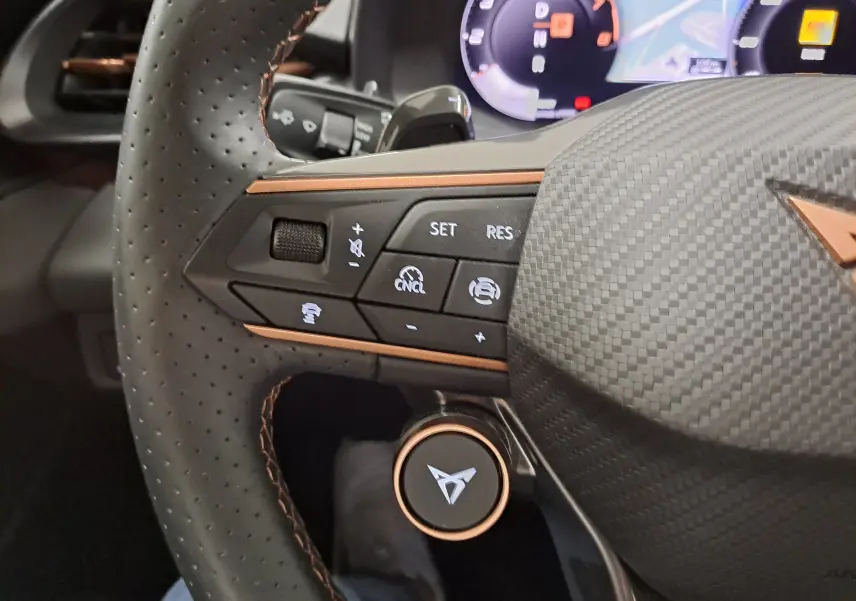 Gros plan sur le volant perforé avec commandes intégrées et logo CUPRA, intérieur du Terramar 2025 Noir Minuit.
